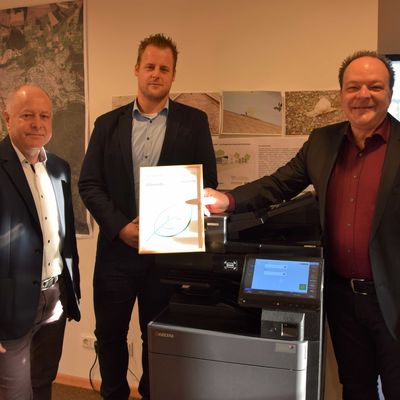 Werner Mukof, Fa. Fröhlich GmbH, und Hendrik Maas, Fa. ekom 21, überreichten die Urkunde der Klimaschutzorganisation myclimate mit dem Nachweis, dass durch die Kopierer-Umstellung 22,024 Tonnen Co2 kompensiert wird. 