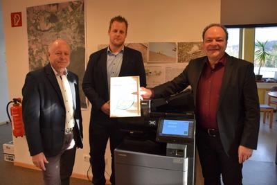 Bild vergr��ern: Werner Mukof, Fa. Fr�hlich GmbH, und Hendrik Maas, Fa. ekom 21, �berreichten die Urkunde der Klimaschutzorganisation myclimate mit dem Nachweis, dass durch die Kopierer-Umstellung 22,024 Tonnen Co2 kompensiert wird. 