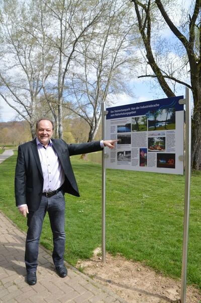 Bild vergr��ern: B�rgermeister Arnim Ro� vor der neuen Informationstafel, die die Entwicklung von der Industriebrache zum Naherholungsgebiet beschreibt.