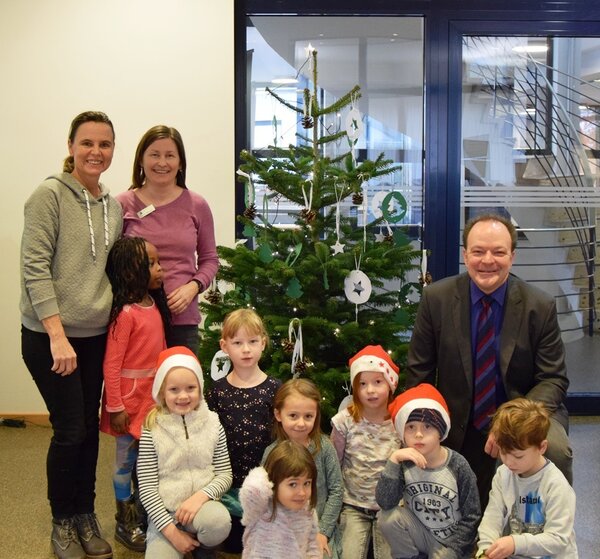 Bild vergr&ouml;&szlig;ern: Kinder und Erzieherinnen der Kita Im Feldhof hielten die Tradition aufrecht, den Weihnachstbaum im Rathaus zu schm&uuml;cken: