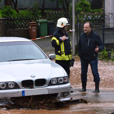 Beim Hochwasser im Mai 2019 bespricht sich Bürgermeister Arnim Roß mit einem Mitglied der Feuerwehr. 