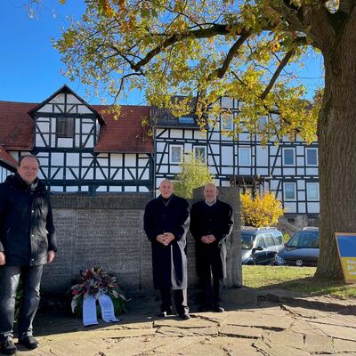 Bild vergr&ouml;&szlig;ern: Am Mahnmal wurde ein Kranz niedergelegt, v.l.n.r.: Bürgermeister Arnim Roß und die Mitglieder des Gemeindevorstand, Arndt-Elfried Grodzicki und Martin Lange.