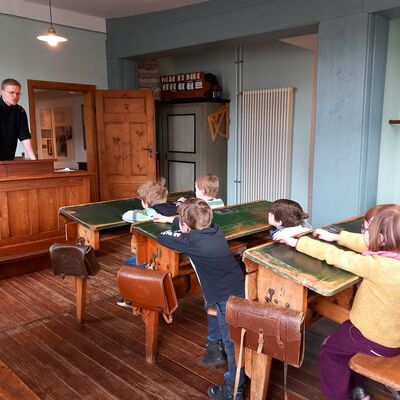 Bild vergr&ouml;&szlig;ern: Das Highlight der Führung: Im historischen Klassenzimmer spricht Jan Terhaar mit den Kindern darüber, wie der Unterricht vor über hundert Jahren war.