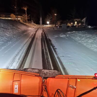 Bild vergrößern: Schichtbeginn mitten in der Nacht: Der Blick aus einem Winterdienstfahrzeug auf die verschneiten Straßen.