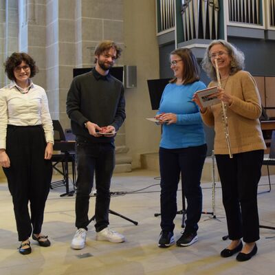 Bild vergr��ern: Mit dem neuen Stiftskirchen-Entdeckerf�hrer und einer Mozartkugel dankte Pfarrerin Bickel dem Fl�tentrio.