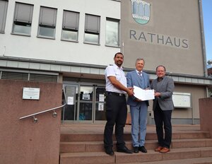 Bild vergr��ern: B�rgermeister Arnim Ro� (r.) und Gemeindebrandinspektor Brian Edokpolor (l.) nahmen den F�rderbescheid von Innenstaatssekret�r Martin R��ler entgegen.