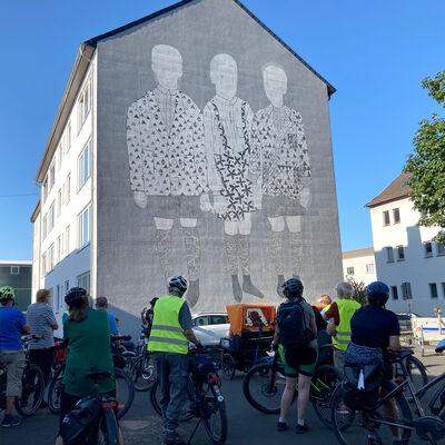 Bild vergr&ouml;&szlig;ern: Als Vorlage diente der aus Polen stammenden Künstlerin Alicja Biala ein Foto aus dem Familienalbum. Ihre Großmutter arbeitete an einer Grundschule für im Krieg erblindete Kinder. Die drei Jungen waren ihre Schüler. Der reduzierte, grafische Stil des „Murals“ fällt sofort auf.