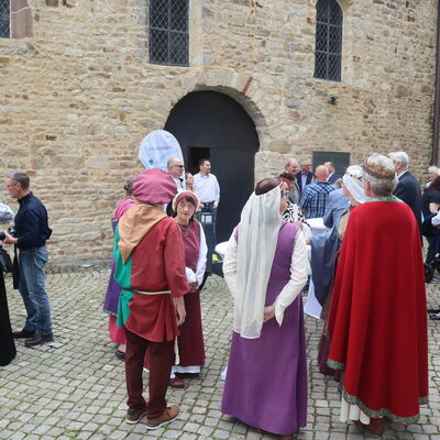Bild vergr&ouml;&szlig;ern: Menschen stehen vor der Stiftskirche.