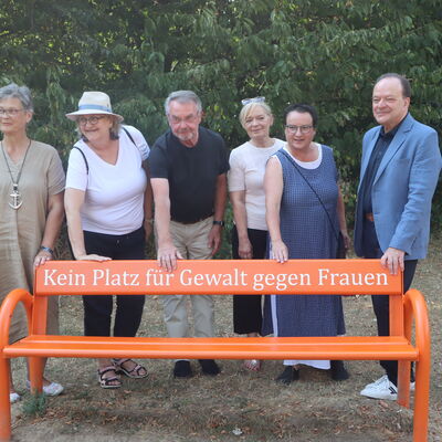 Bild vergr&ouml;&szlig;ern: Kein Platz für Gewalt gegen Frauen – eine starke Botschaft auf Kaufungens erster Orange Bank. Bei der Einweihung dabei: (v.l.) Anette Milas (Frauenbeauftragte Landkreis Kassel, Christiane Röhlig (Mitglied des Gemeindevorstands), Reinhard Zymzak (Mitglied des Gemeindevorstands), Katja Schöne (Sozialwissenschaftlerin), Angelika Schinkel (Initiatorin), Arnim Roß (Bürgermeister).