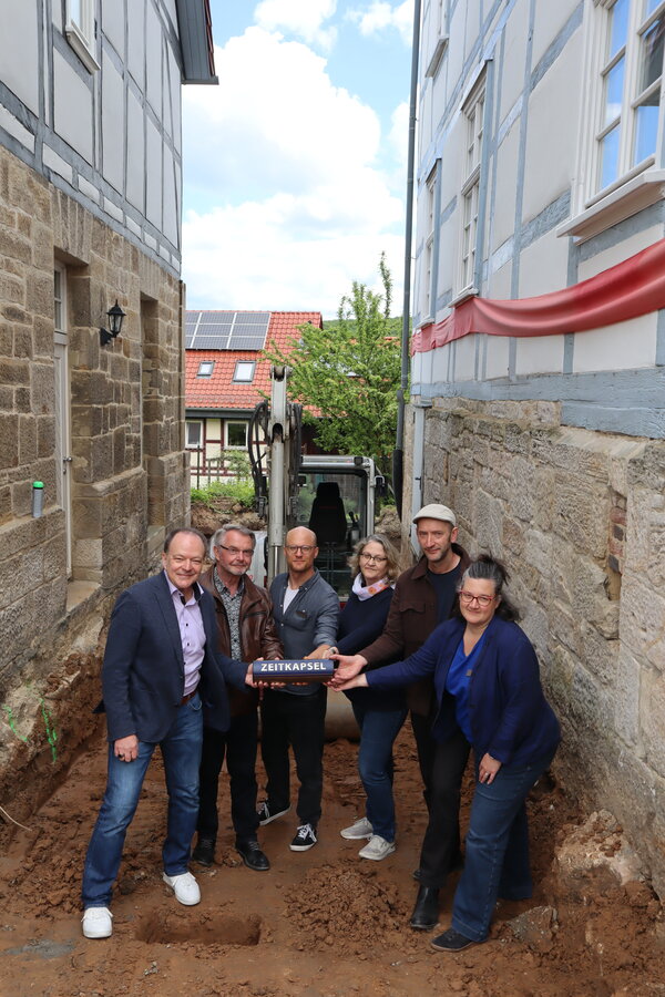 Mit dem Versenken einer „Zeitbulle“ wurde der Grundstein zum Bau des Verbindungsgebäudes zwischen Museum und Mitmachhaus symbolträchtig begangen: v.l. Bürgermeister Arnim Roß, Beigeordneter Reinhard Zymzak, Museumsleiter Hauke Homeier, Beigeordnete Christiane Röhling, Architekt Markus Hanisch und Museumsmitarbeiterin Sabine Bulik. 