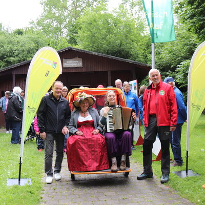 Bild vergr&ouml;&szlig;ern: Ein farbenfroher Auftakt am Steinertsee: Bürgermeister Arnim Ross und Horst Hoffmann von der Wanderschule Nieste mit Hiltrud Gunkel und Charlotte Haubrich in der Rikscha.